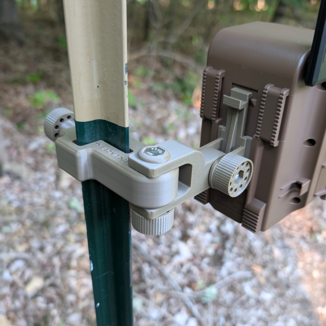 Close-up of a hunting camera attached to a pole with a natural background
